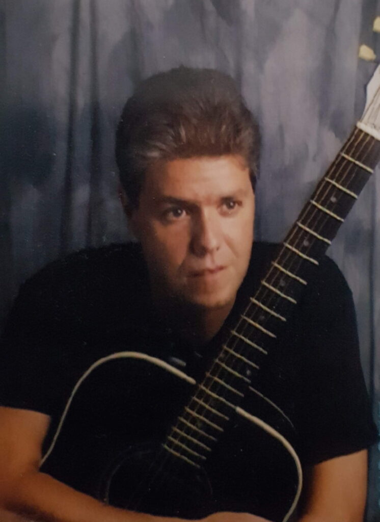 ROB PIERCE holding guitar